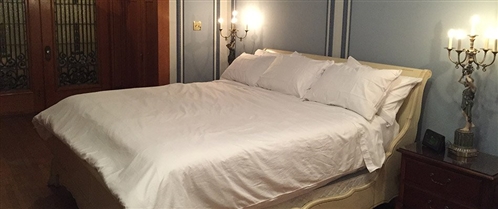The Wilhelm Suite - king bed beneath period sconces at The Inn at Centre Park